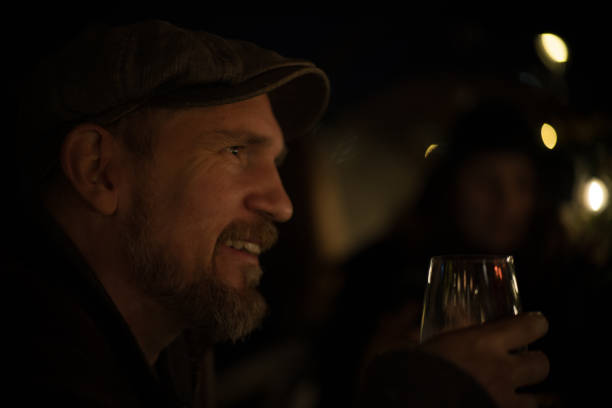 istock Smiling Bearded Man in 40s with high cheek bones in a cap toasts his first date on a romantic winter dinner. 2183826668