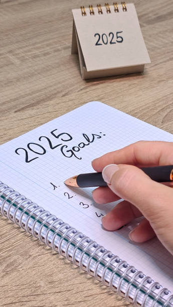 istock Unrecognizable hand holding a pen while writing his new goals for the year 2025 2183837154
