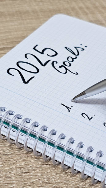 istock Unrecognizable hand holding a pen while writing his new goals for the year 2025 2183837169