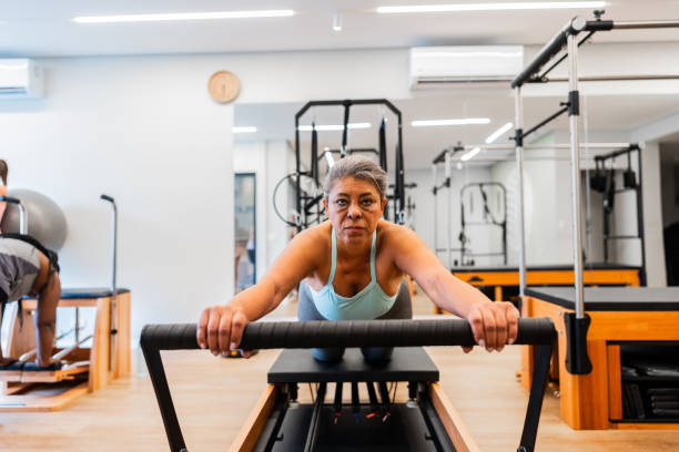 istock Mature woman exercising on reformer at a pilates studio 2183838830
