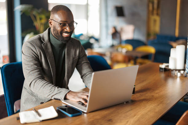 istock Happy man using laptop in stylish modern cafe. 2183841349