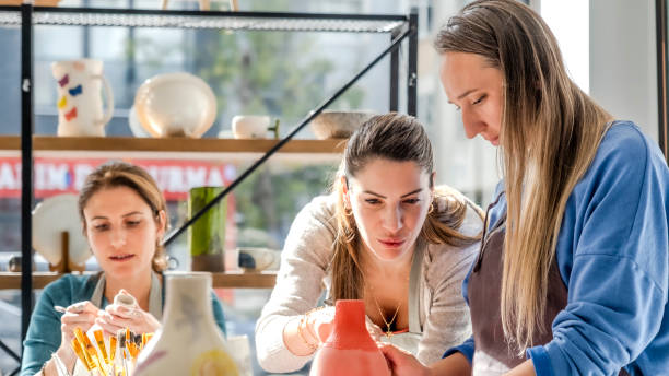 istock In an art studio with an environment adorned with artistic paintings in the background, three beautiful middle-aged women friends are happily drawing patterns and painting the vases they made from clay at a table filled with art supplies 2183843401