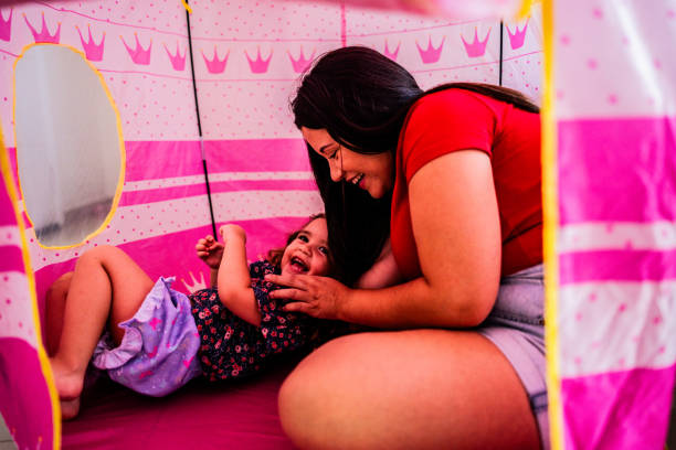 istock Young mother playing with her daughter at home 2183843901
