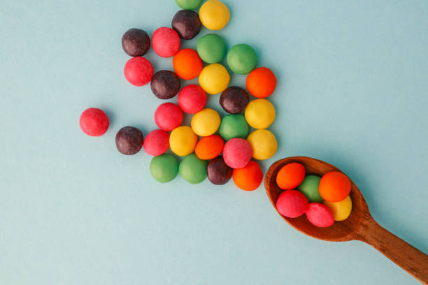 Chocolate round candies scattered on a soft blue background