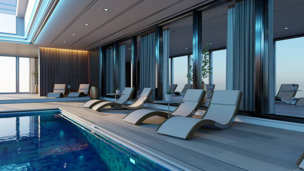 istock Modern indoor pool with elegant lounge chairs positioned around it. Large windows provide a breathtaking view during sunset, enhancing the atmosphere of relaxation. 3d render 2183845632