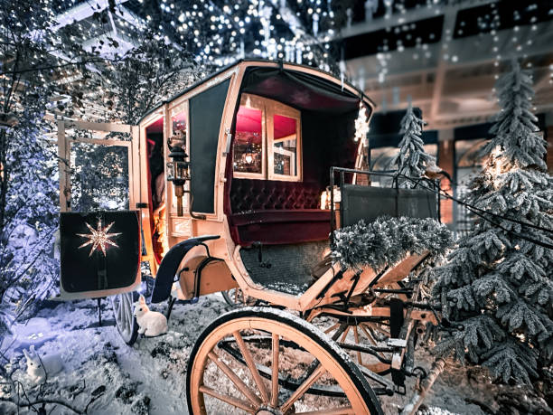 This magical holiday scene features a beautifully preserved vintage carriage adorned with festive garlands and twinkling lights, set in a snowy forest-like setting. The carriage's interior glows warmly with elegant red upholstery, creating a cozy and inviting atmosphere. Snow-dusted pine trees surround the display, enhancing the winter wonderland ambiance. The delicate lights hanging above add a touch of enchantment, making this a perfect depiction of classic holiday charm blended with nostalgic elegance. A whimsical and picturesque representation of Christmas spirit.
