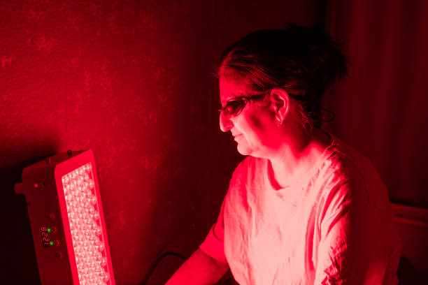istock Senior Woman doing the Red Light Therapy Session with Panel at home 2183853060