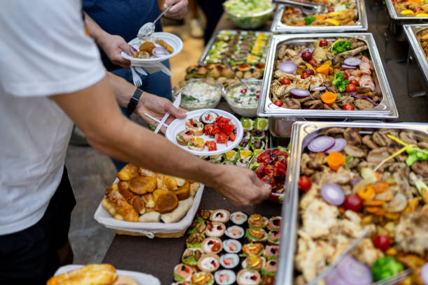 istock Guests enjoy a diverse buffet spread with various dishes at a gathering in a banquet hall during an evening event 2183854686