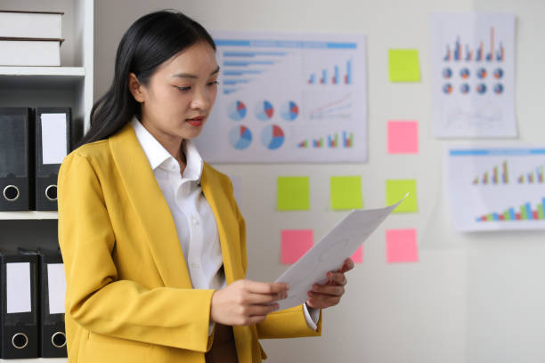 istock Woman working in the office holding a file and reading documents. 2183855964