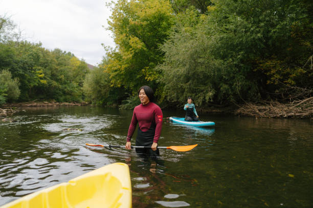 istock Paddleboarding and kayaking together on the river 2183859442