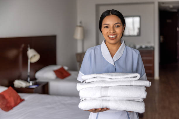 istock Happy maid working at a hotel holding towels while smiling at the camera 2183861999