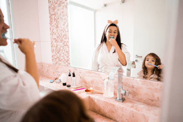 istock Mother and daughter brushing teeth in the bathroom 2183862237