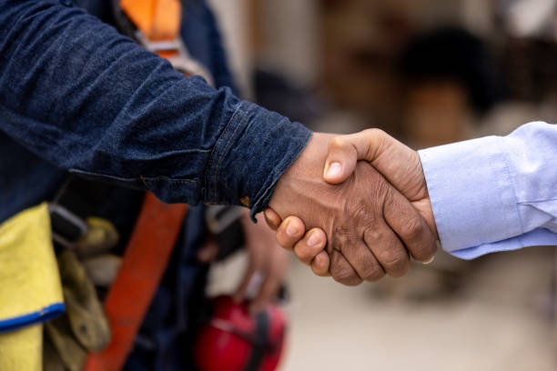 istock Close-up on a building contractor handshaking with an architect 2183863055