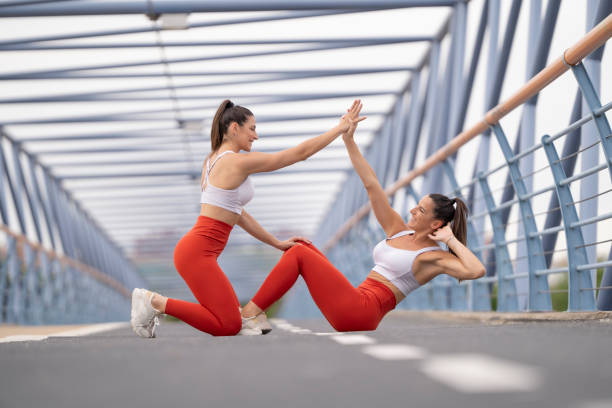 istock Two women high-fiving in bridge setting after completing core workout exercise outdoors 2183863376