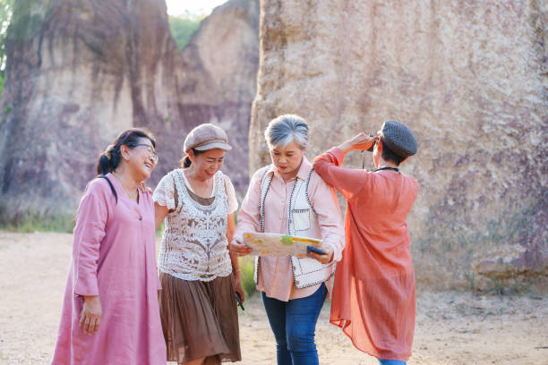 istock Group of senior women friends looking at a map while exploring a natural landscape with large rock formations. Their smiles and attentiveness highlight their adventurous spirit and strong friendship. 2183864800