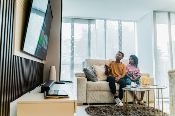 istock Siblings watching tv on sofa at home 2183866412