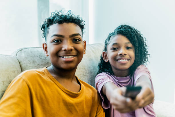 istock Siblings watching tv at home 2183866414