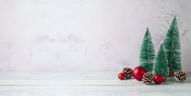 istock Empty wooden whhite table with pine tree decorations over bright wall  background. Christmas mock up for design and product display 2183868551
