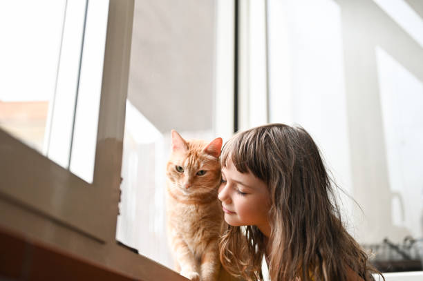 Little girl embracing with ginger cat.