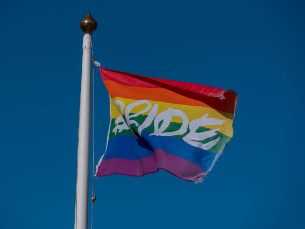 istock Rainbow flag with the inscription pride on the flagpole. Rainbow flag on a sky background. 2183876235