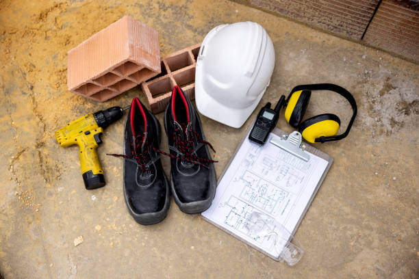 Close-up on construction tools and protective workwear at a building site - occupational safety and health concepts