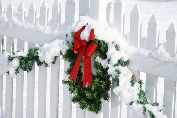 Christmas wreath on the white fence after snow