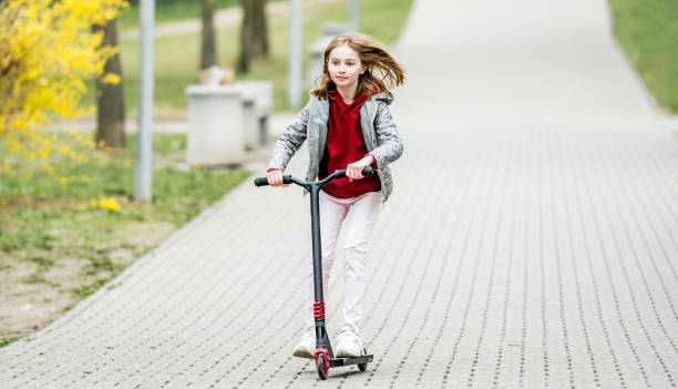 istock Little cute girl riding a scooter 2183879809