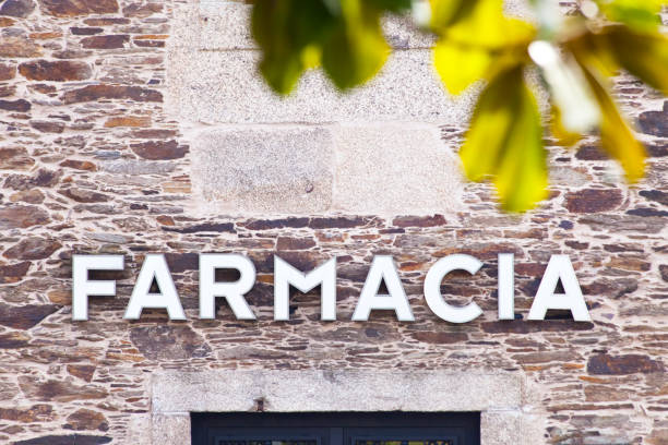 Pharmacy sign in spanish language over front door. Stone wall facade. Santiago de Compostela, Galicia, Spain.