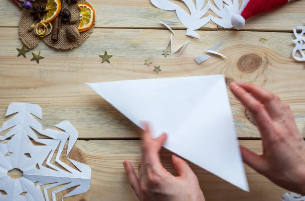 istock A snowflake made from paper with your own hands gracefully decorates a winter interior, adding warmth and a cozy atmosphere 2183881973