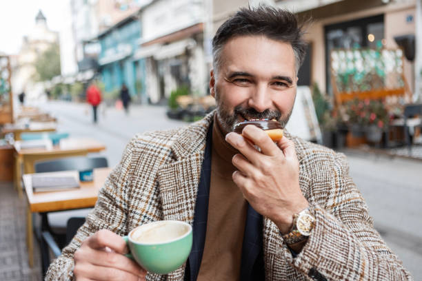 istock Businessman Savoring Doughnut and Hot Coffee 2183882475