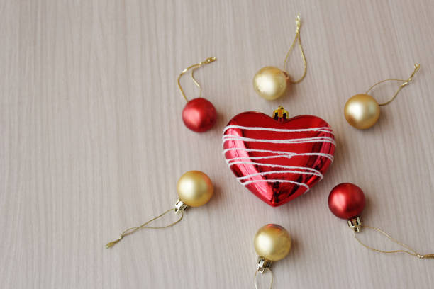 Red and golden xmas balls and heart shape ornament for winter season holiday celebration. Also suitable for artificial insemination concept. Copy space available.