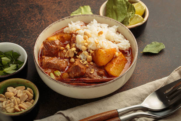 istock Bowl of massaman curry with beef, potatoes, rice, and peanuts, garnished with cinnamon, traditional dish of Thailand 2183888313