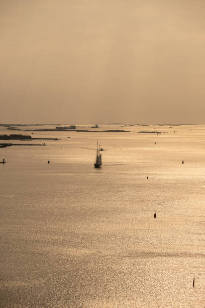 Sail ship arriving port in evening light.