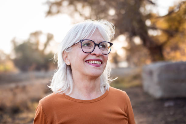 istock Elderly Woman Smiling Outdoors in Autumn Light 2183898308