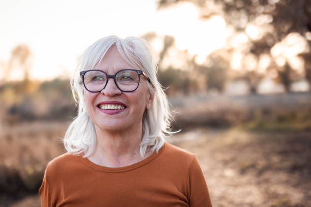 istock Elderly Woman Smiling Outdoors in Autumn Light 2183898312