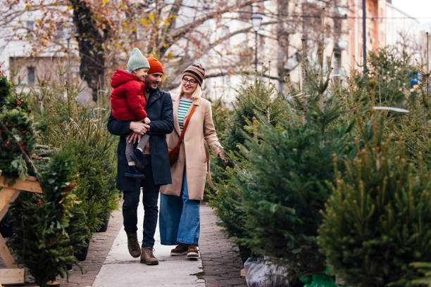 istock Happy Family Choosing Christmas Tree for Holiday Celebration 2183898437