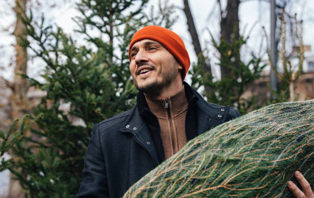 istock Joyful Man Carrying Fresh Christmas Tree Outdoors in Winter 2183898467