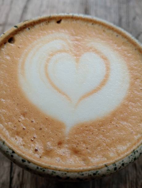 istock Coffee Cup with Heart-Shaped Foam Art on Rustic Wooden Table 2183902191