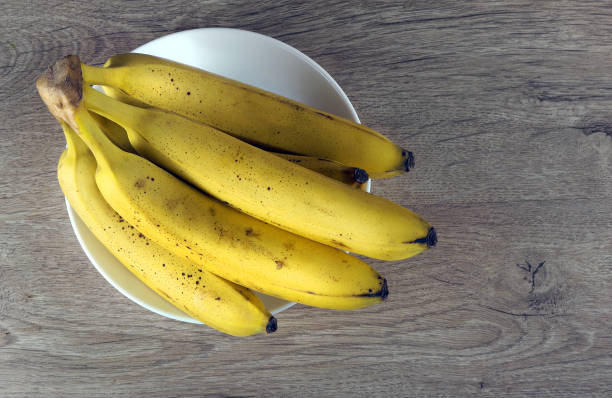 istock bright ripe bananas on a wooden table. top view 2183904256