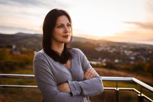 istock Serene Woman Reflecting Outdoors at Sunset in Tranquil Landscape 2183911151