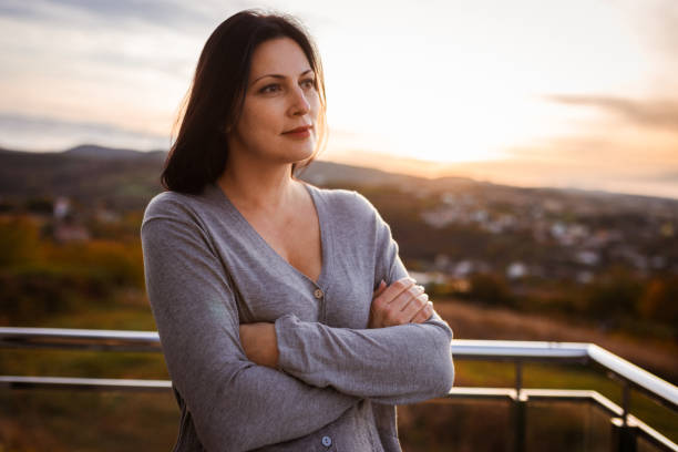 Serene Woman Reflecting Outdoors at Sunset in Tranquil Landscape