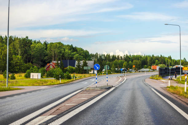 A highway with light traffic through a rural landscape on a summer night in the Dalarna region of Sweden.