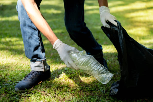 istock Hand holding plastic bottle waste, picking up trash and putting it in the black garbage bag at the Park on Environmental Earth day 2183929264