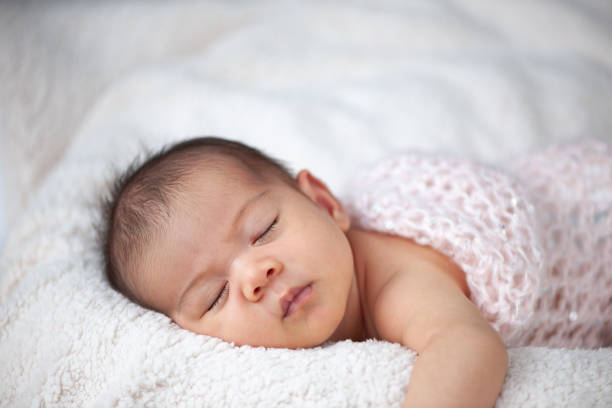 Peaceful close-up shots of a newborn baby sleeping on a soft, cozy blanket, capturing innocence and tenderness