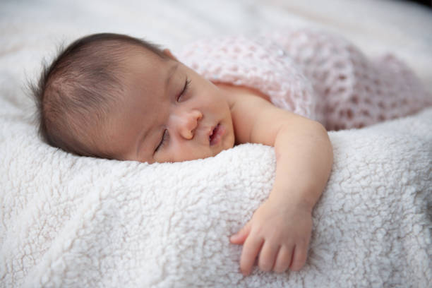 istock Close-up of Sleeping Newborn Baby on Soft Blanket 2183929552