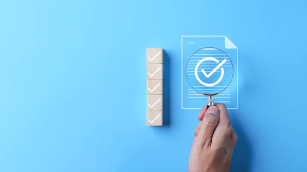 istock Quality assurance document control concept. Businessman holding magnifying glass focus on correct sign mark with document approved paperless and quality assurance approve, Checkmark on wood cube, 2183948423