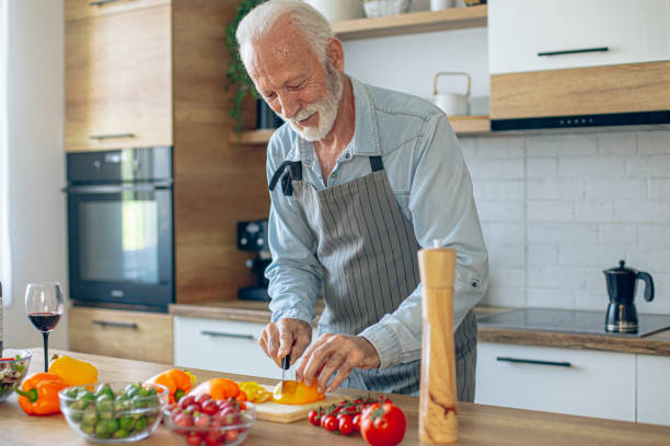 istock Senior man in kitchen cooking healthy meal 2183948424