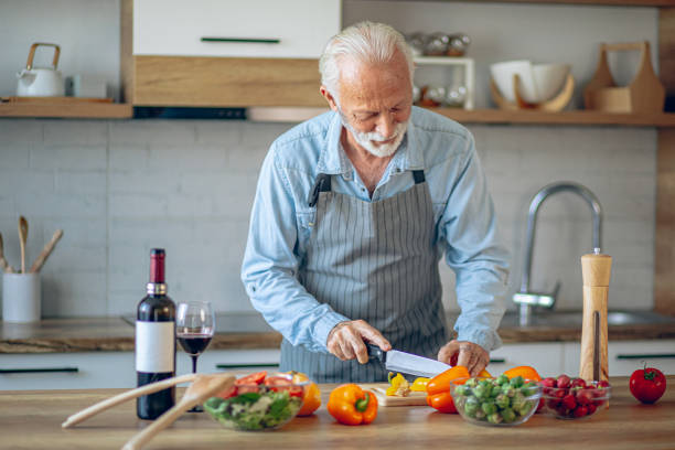 istock Senior man in kitchen cooking healthy meal 2183948450