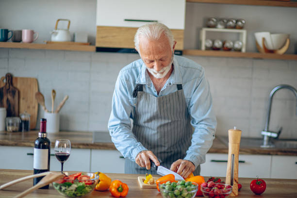 istock Senior man in kitchen cooking healthy meal 2183948637