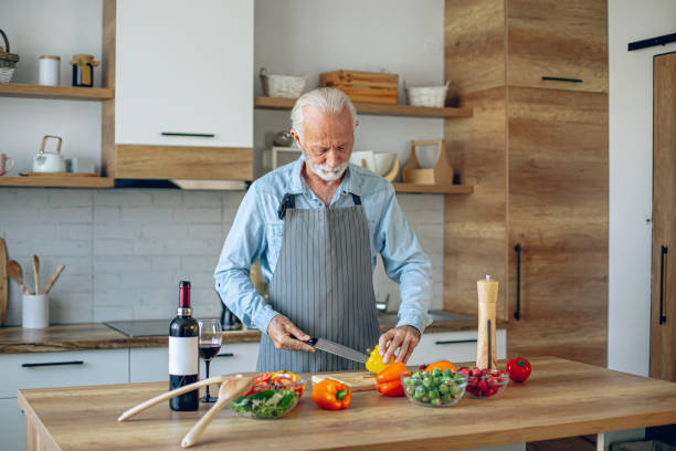 istock Senior man in kitchen cooking healthy meal 2183948707